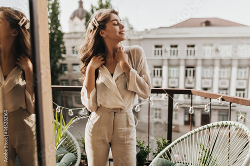 Photos Curly woman enjoys sunny day on terrace