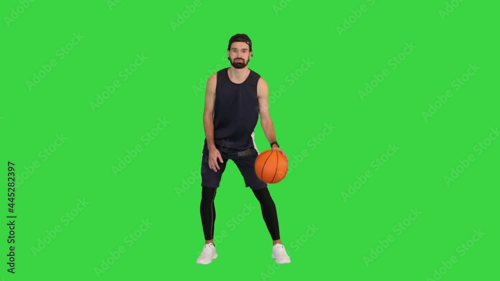 Basketball player bouncing a ball on a Green Screen, Chroma Key. Stock