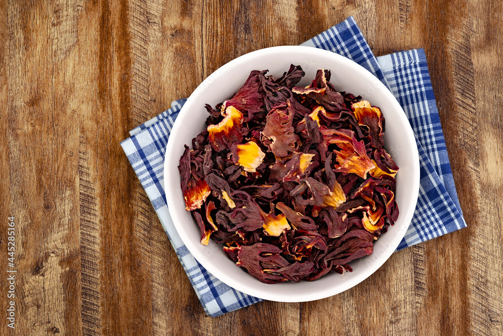 Dry Organic Jamaica Flower Hibiscus for Tea. Top view of bowl with Jamaica Flower Hibiscus. Detailed view of hibiscus tea on wooden background Dry Organic Jamaica Flower Hibiscus for Tea. Top view of bowl with Jamaica Flower Hibiscus. Detailed view of hibiscus tea on wooden background