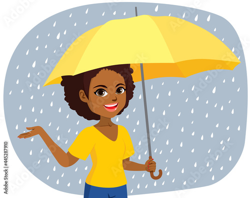 Young happy black woman under umbrella with raining weather touching raindrops autumn concept