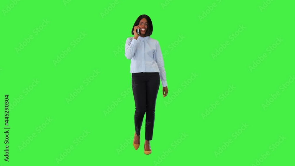 Smiling woman talking on smart phone Happy young african businesswoman speaking mobile and walking on a Green Screen, Chroma Key. Smiling woman talking on smart phone Happy young african businesswoman speaking mobile and walking on a Green Screen, Chroma Key.