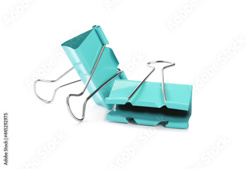 Turquoise binder clips on white background. Stationery