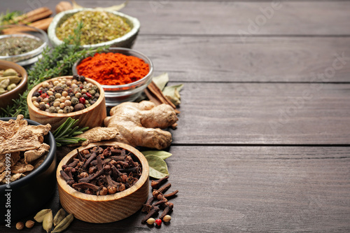 Different natural spices and herbs on wooden table. Space for text © New Africa