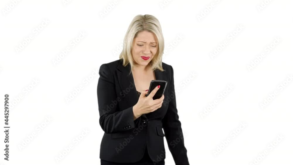 Attractive blonde business woman angry and updet as she loses money on a game app on her phone with white background Attractive blonde business woman angry and updet as she loses money on a game app on her phone with white background