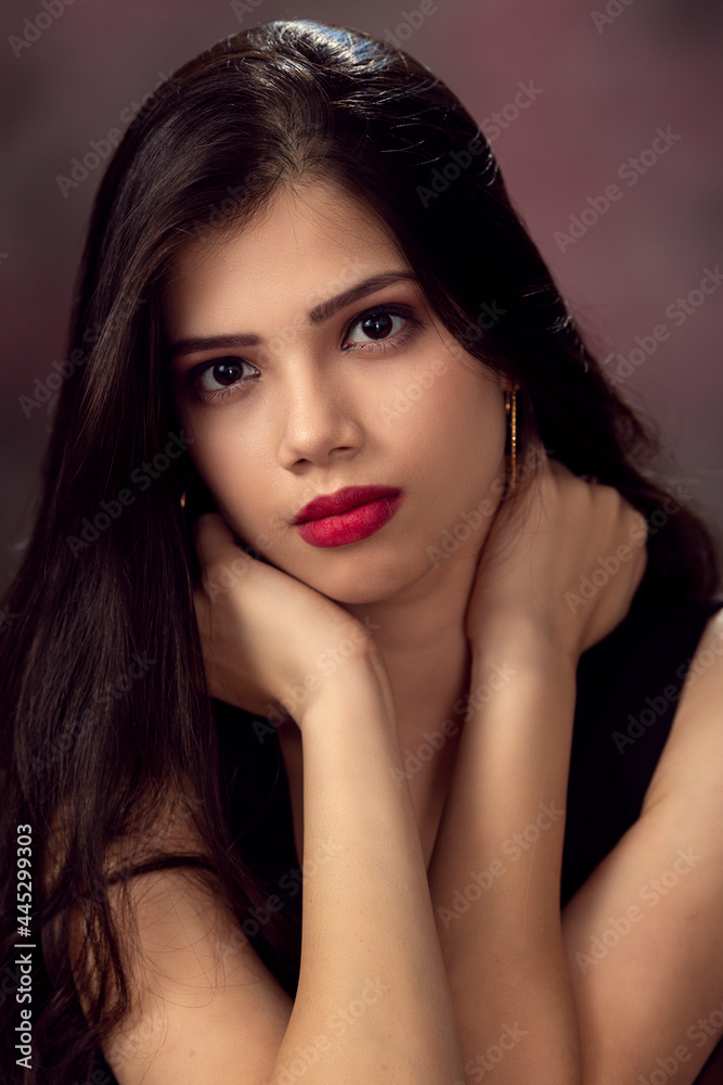 Fashion photo of a beautiful model with long hair, wearing black top, fashion pose, studio portrait, dark background, close up pic. Fashion photo of a beautiful model with long hair, wearing black top, fashion pose, studio portrait, dark background, close up pic.