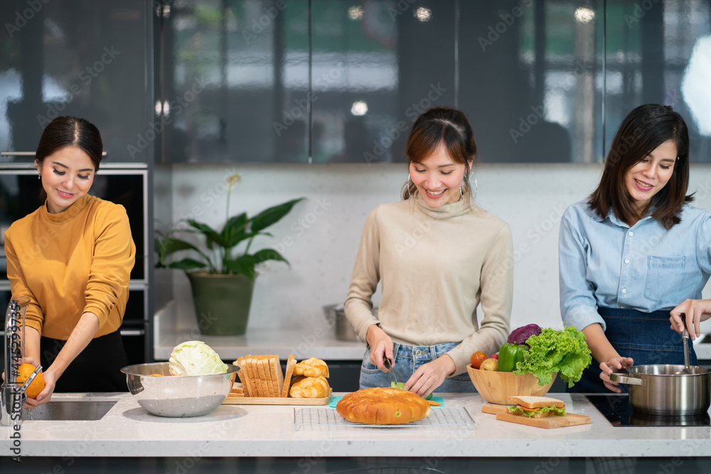 Young Asian Woman Friends Cooking Together in Home Kitchen
