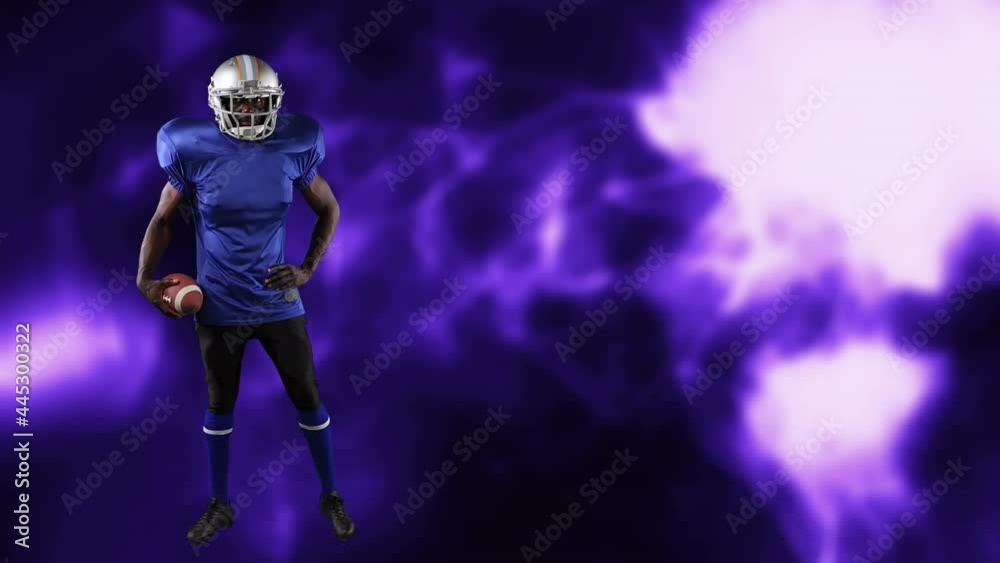 American football player holding ball over light trails American football player holding ball over light trails