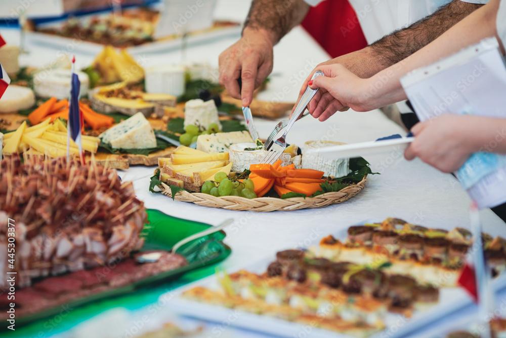 Shallow depth of field (selective focus) image with people eating french cuisine aperitifs from a table.