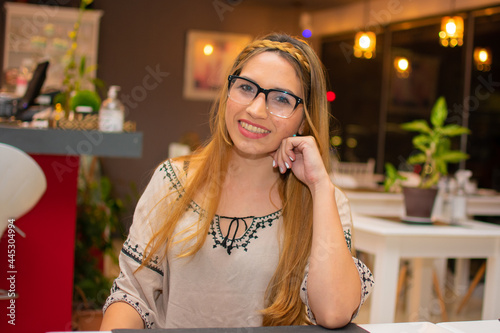 mujer hermosa con trenza tomando cafe y jugo de naranja en una cafeteria