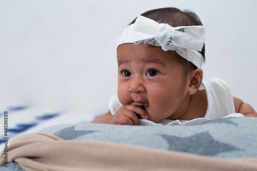 Closeup portrait of cute baby girl dress in white dress, biting her fingers and looking away. Closeup portrait of cute baby girl dress in white dress, biting her fingers and looking away.