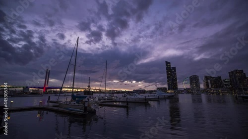 Sunset timelapse video of Bolte Bridge with Melbourne Star Observation Wheel at District Docklands in Melbourne CBD, Australia