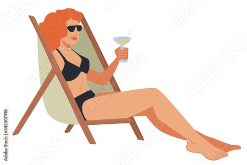 Woman in swimsuit drinking cold cocktail in chair