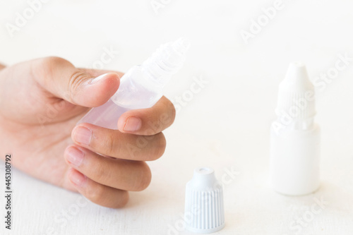 hand of girl holding lubricant eye drops for dryness and imitation teardrop of the eye with sterilize eye drops medicine for eye on background white 