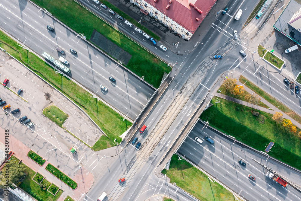 aerial top view of city road intersection with traffic bridge and moving cars