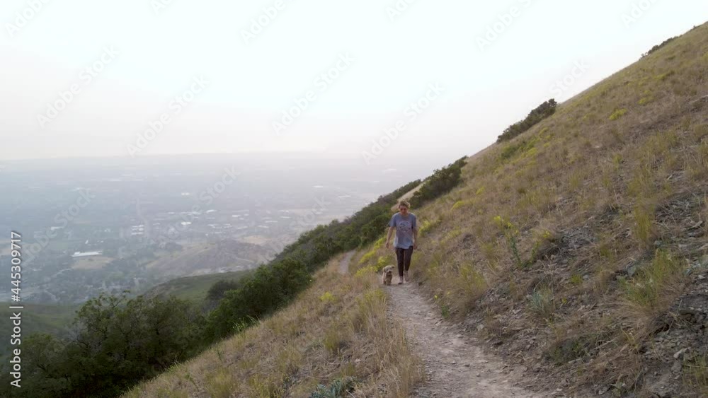 Caucasian Woman and Doodle Puppy Walking on Hiking Trail in Utah Mountains Caucasian Woman and Doodle Puppy Walking on Hiking Trail in Utah Mountains