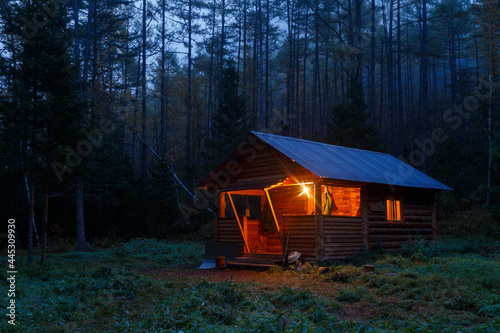Sikhote-Alin Biosphere Reserve. A wooden hut stands in a dense forest in the middle of the night. The hunter's house of the forester in the Far Eastern taiga.