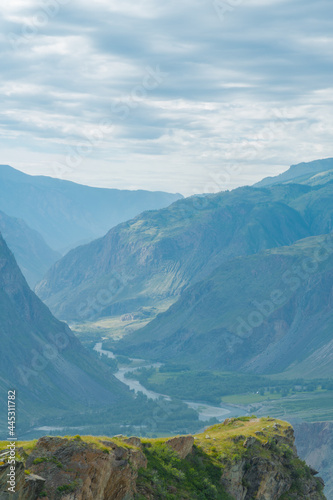 A green rocky cliff rises above the canyon of the Chulyshman river valley, vertical Altai photo © Stan Stocking