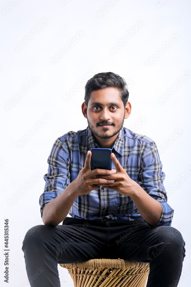 Young indian man using smartphone over white background. Young indian man using smartphone over white background.