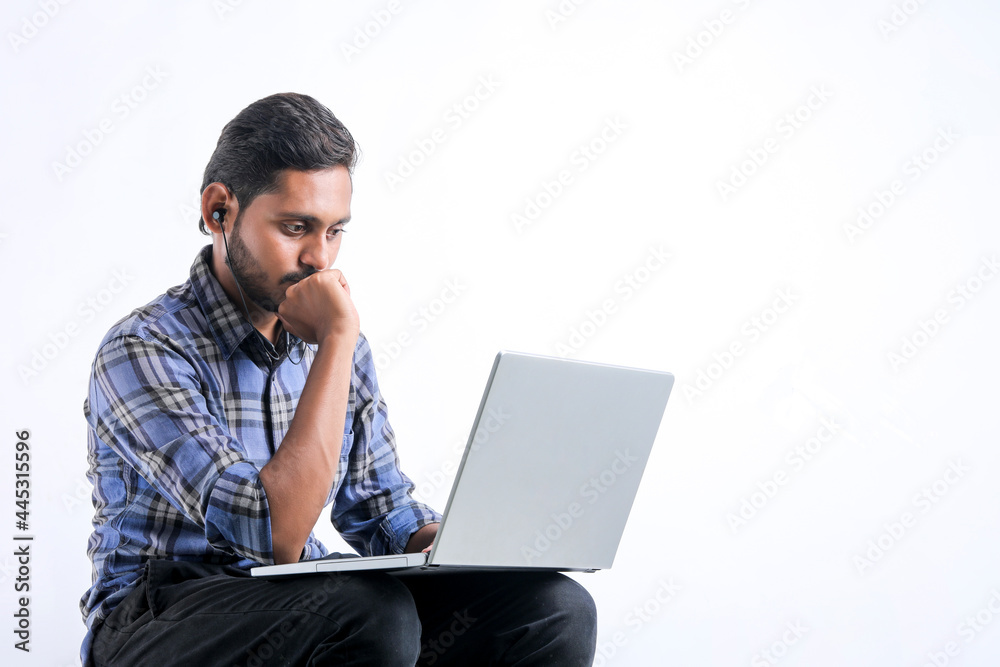 Young indian man using laptop over white background. Young indian man using laptop over white background.