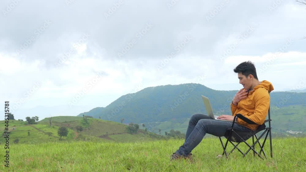 Asian businessman working on laptop computer for online stock trading or small business on the mountain. Modern handsome man enjoy outdoor lifestyle with using wireless technology on summer vacation. Asian businessman working on laptop computer for online stock trading or small business on the mountain. Modern handsome man enjoy outdoor lifestyle with using wireless technology on summer vacation.