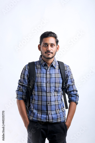 Young indian college student with bag pack on white background.