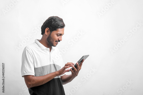 Young indian man using tablet over white background.