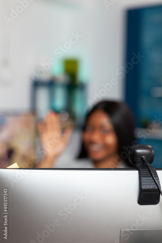 Selective focus on computer webcam while african american student greeting professor during online videocall meeting conference. Black woman working remote from home using elearning platform