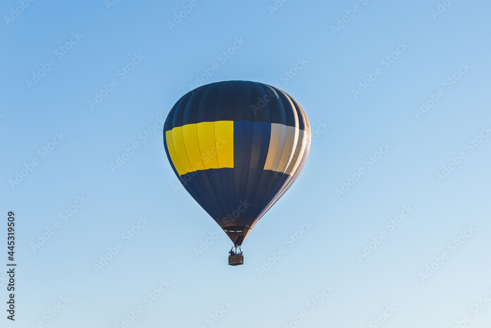 Fototapeta premium Hot Air Balloon on a blue sky.One Blue yellow hot air balloon in blue clear sky.