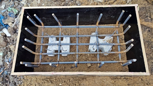 Steel grid square or iron wire column footing in shutter boards waiting for ground beam reinforced concrete work.