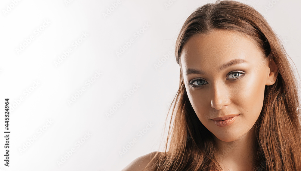 Beautiful young girl smiling and posing looking at the camera on a white isolated background. Positive brunette woman. Kind look. Beauty face