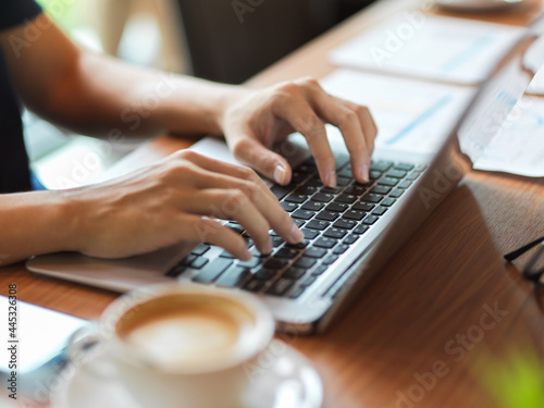 Working woman typing on laptop keyboard