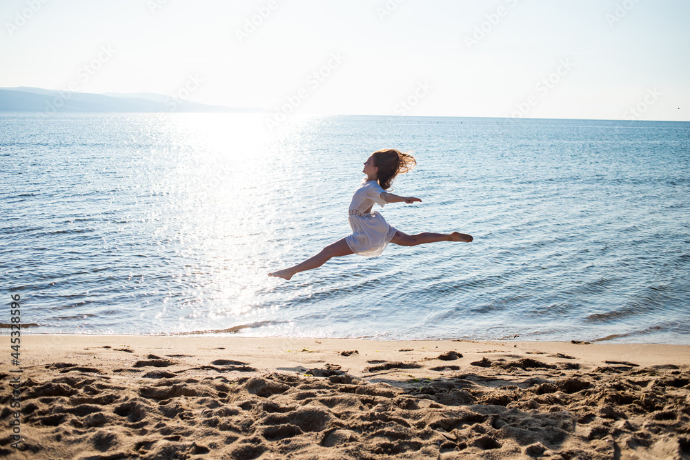 woman running on the beach, dancing and jumping on the beach