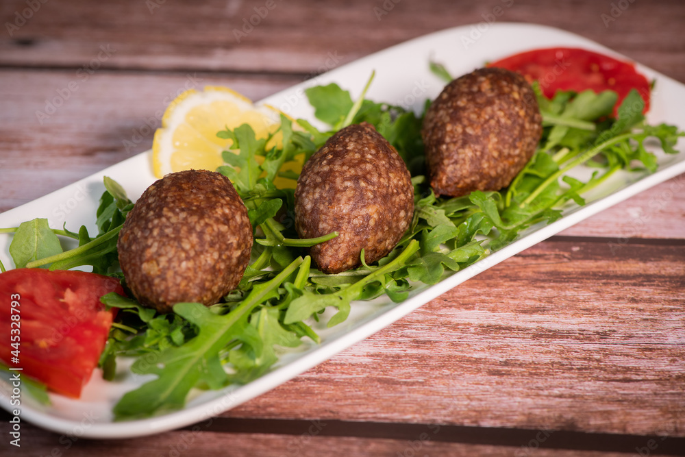 Traditional kebbe and pita bread on big round plate in lebanese restaurant. High quality photo Traditional kebbe and pita bread on big round plate in lebanese restaurant. High quality photo