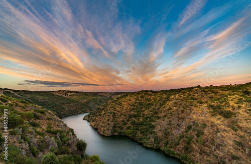 River and canyon at sunset with pink clouds