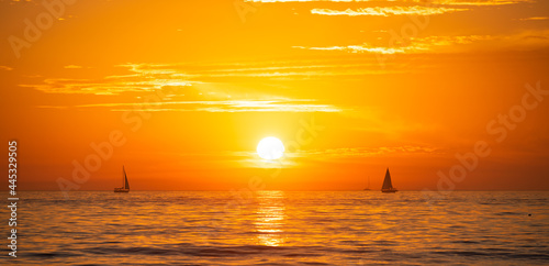 Sailing yacht on sunrise. Seascape golden sunrise over the sea, tenerife. Nature landscape. Beautiful orange and yellow color on ocean sunset. Seascape with gold sky and clouds.