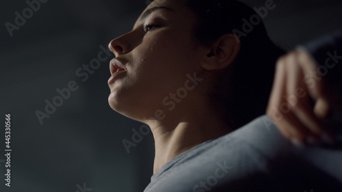 Woman preparing for physical exercises in gym. Female athlete warming shoulders