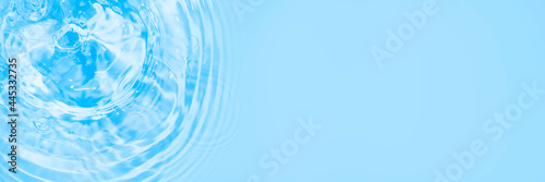 Surface of light blue transparent swimming pool water texture with circles on the water. Trendy abstract nature background. Water waves in sunlight long banner with copy space