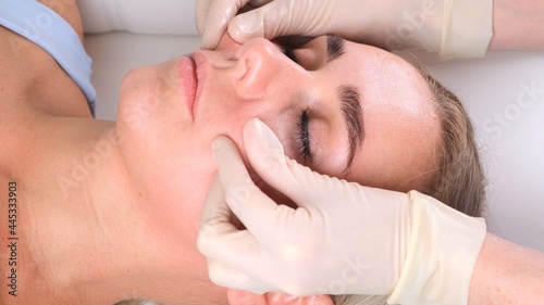 Beautiful woman in salon having facial massage.