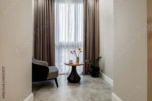 decor elements of the guest room and rest room with a tea table  an armchair and a bouquet of flowers and a cup of coffee