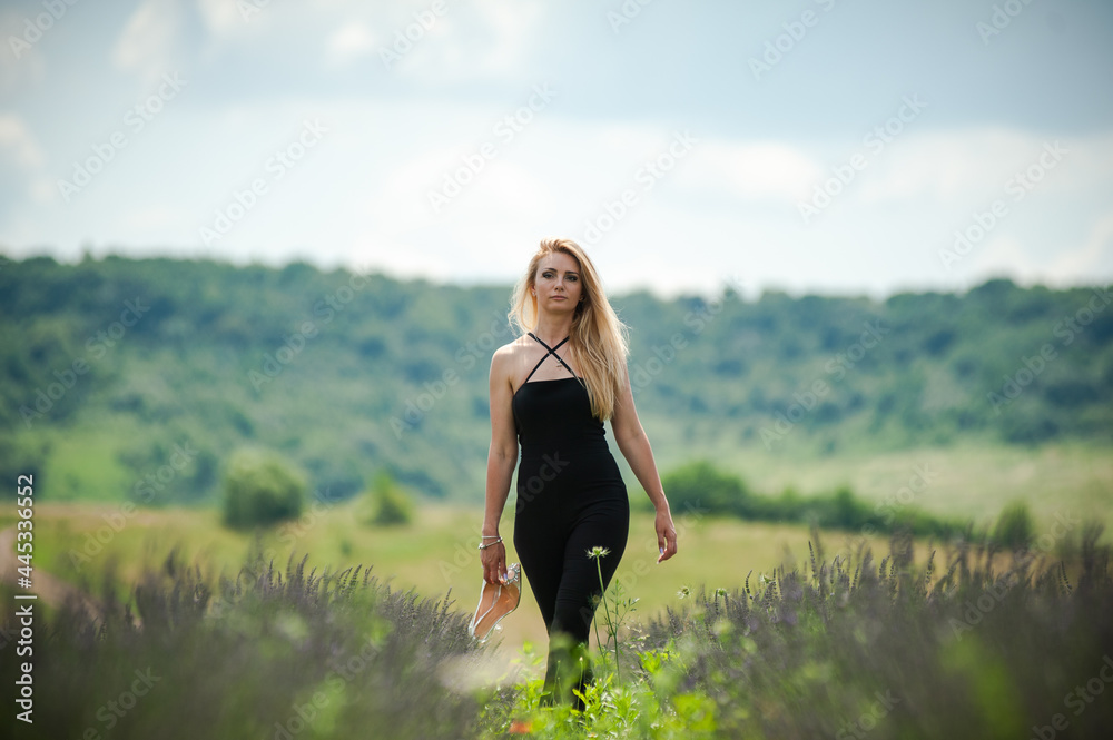 Blonde woman on the garden field in the summer