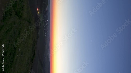 Timelapse Night to Day Transition of moon setting over city lights, vertical video