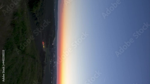 Timelapse Night to Day Transition of moon setting over city lights, vertical video