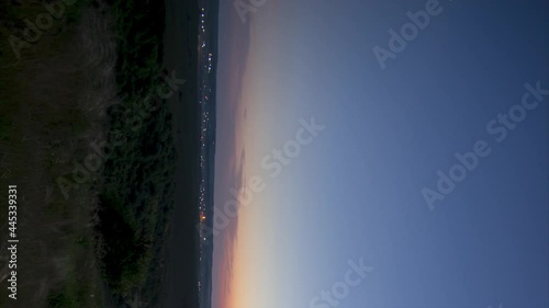 Timelapse Night to Day Transition of moon setting over city lights, vertical video