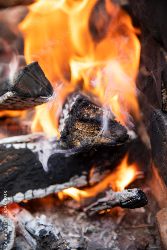 Glowing embers in hot red color, abstract background. The hot embers of burning wood log fire. Firewood burning on grill. Texture fire bonfire embers. Glowing embers in hot red color, abstract background. The hot embers of burning wood log fire. Firewood burning on grill. Texture fire bonfire embers.