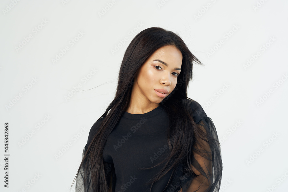 beautiful fashionable woman of african appearance dark shirt long hair light background beautiful fashionable woman of african appearance dark shirt long hair light background