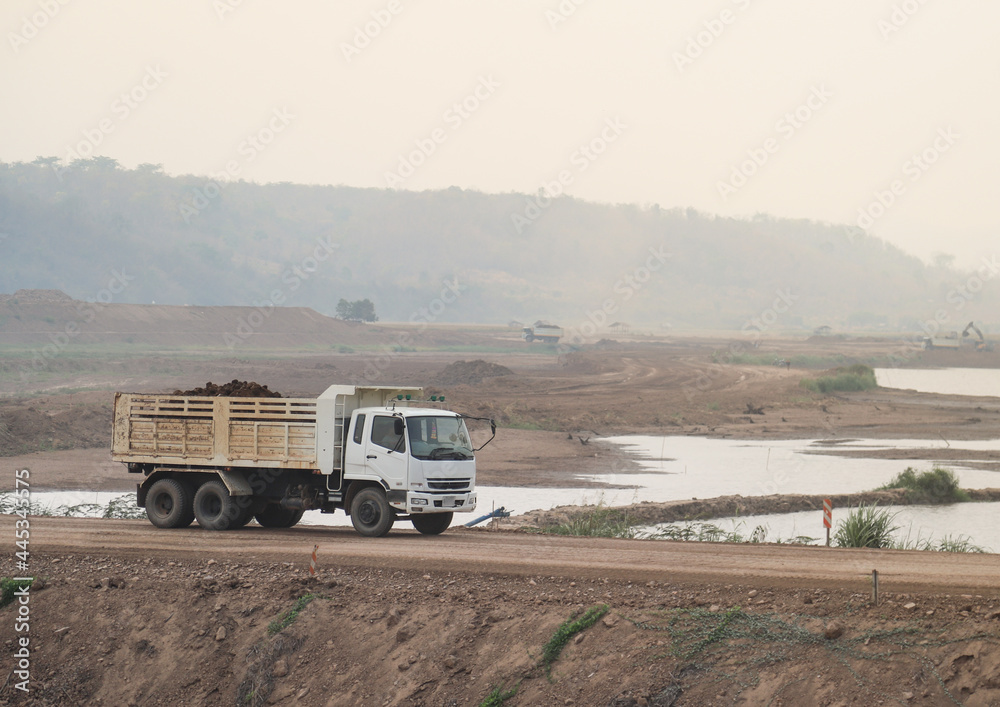 Closeup of dump-truck running on temporary road at construction site.