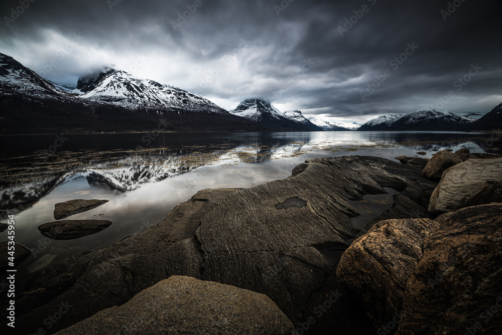 Obraz premium Scenic fjord landscape with snow and refection on a calm cold cloudy winter day in northern norway near Tromso