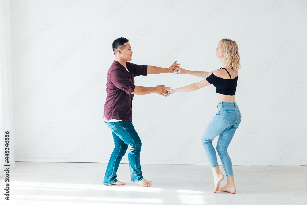 Naklejka premium a man and a woman dance bachata music in a white room