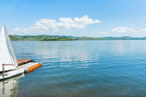 Sailing. A sailboat stands at the pier on the lake photo