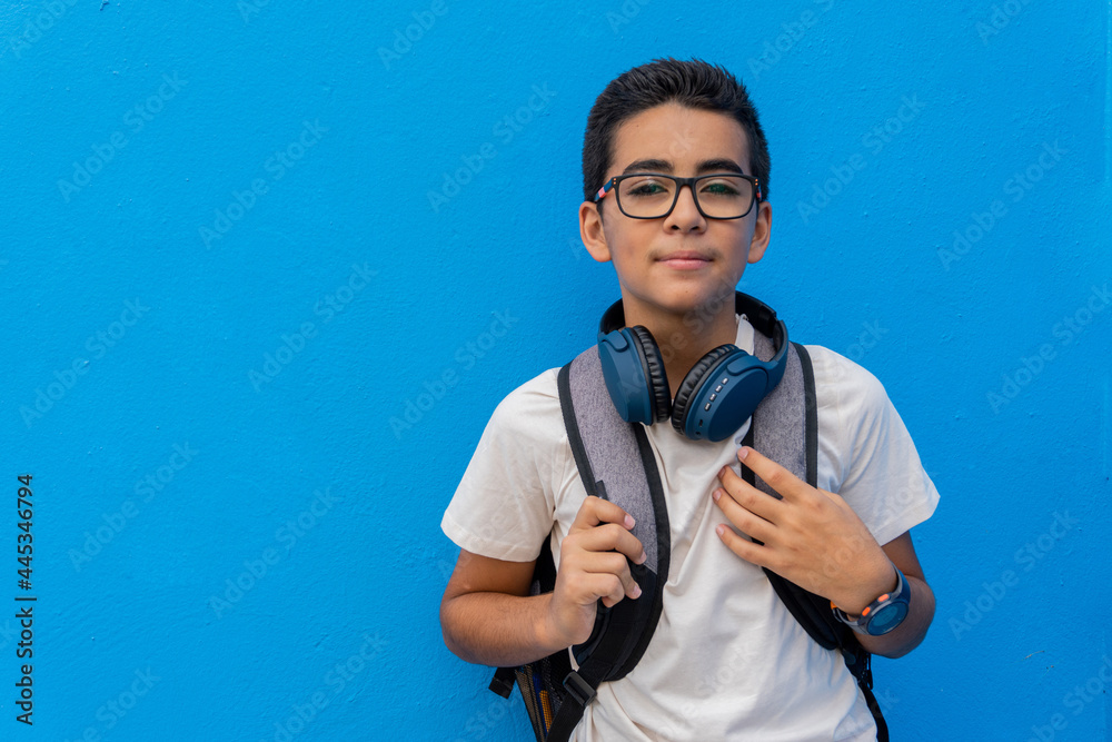 Pre-adolescent in front of a blue school wall Pre-adolescent in front of a blue school wall